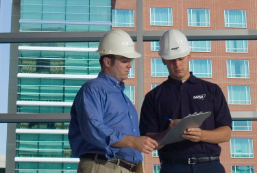 Two SRM technicians reviewing hotel restoration project paperwork